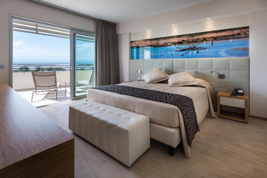 a bedroom with a bed and a view of the ocean at Laguna Park Hotel 4Superior in Bibione