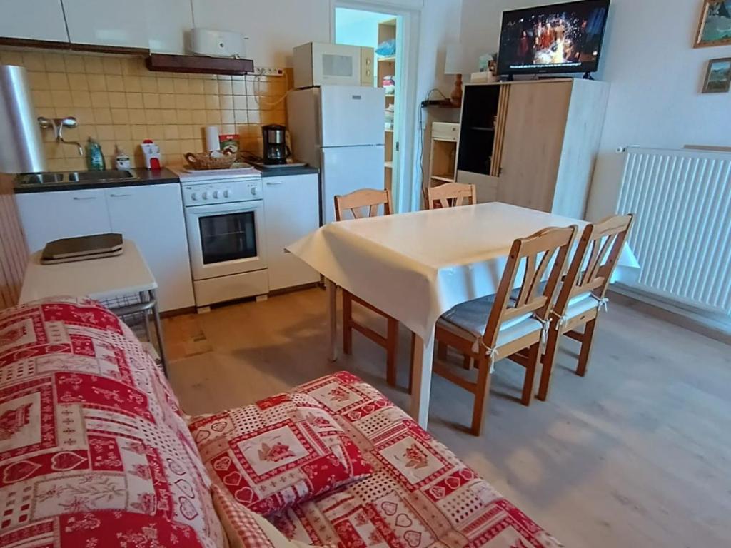 - une cuisine avec une table et un canapé dans une chambre dans l'établissement Appartement Confortable 4 Pers. à Briançon, Jardin Privatif, 300m des Pistes - FR-1-762-8, à Briançon