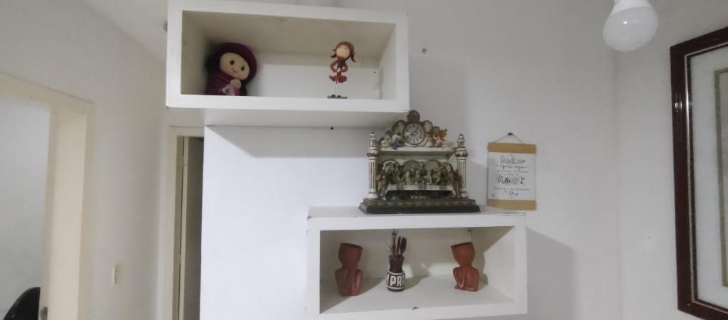 une étagère blanche dans une pièce avec des chaussures dans l'établissement Apto Shalom, à Serra