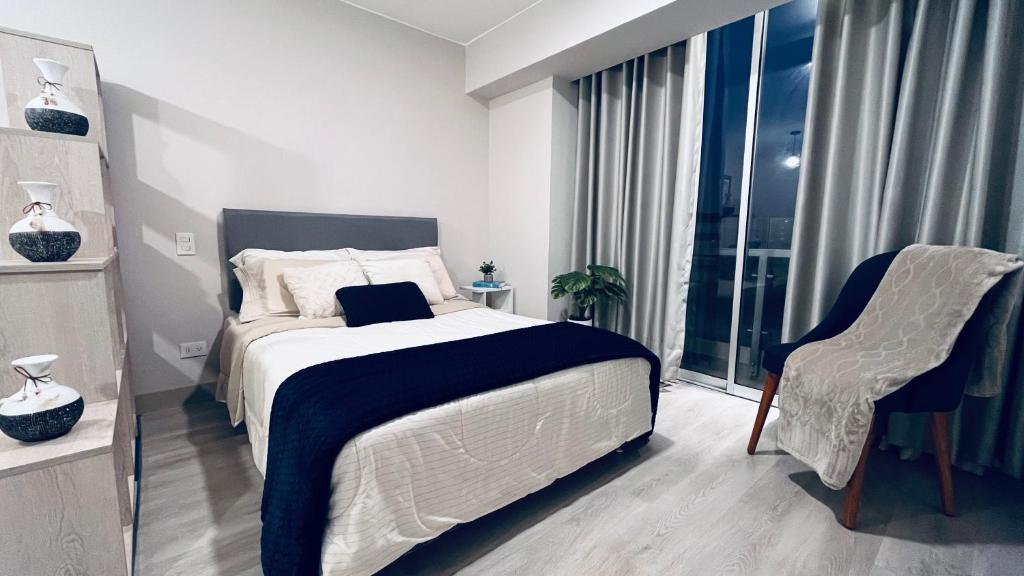 a bedroom with a bed and a chair and a window at Loft céntrico San borja - San Isidro in Lima