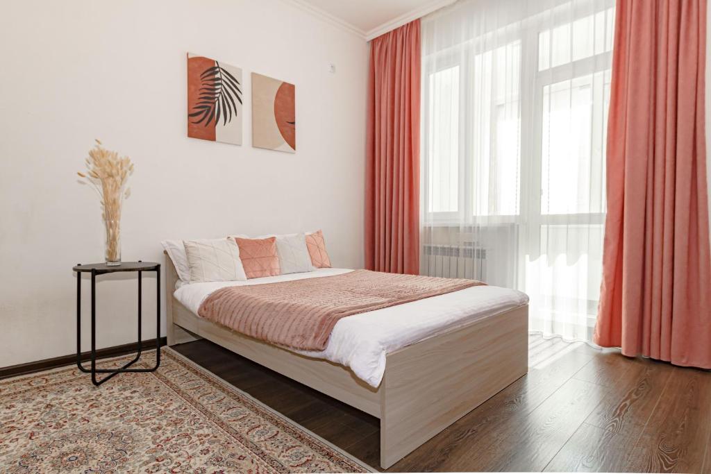 a bedroom with a bed and a large window at Уютная Квартира Expo Boulevar in Astana