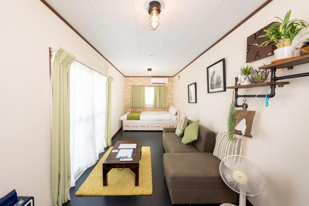 uma sala de estar com um sofá e uma mesa em CH Maezato em Ishigaki Island