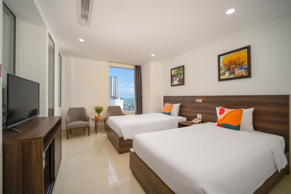 um quarto de hotel com duas camas e uma televisão de ecrã plano em RAON Hotel - STAY 24H em Quy Nhon