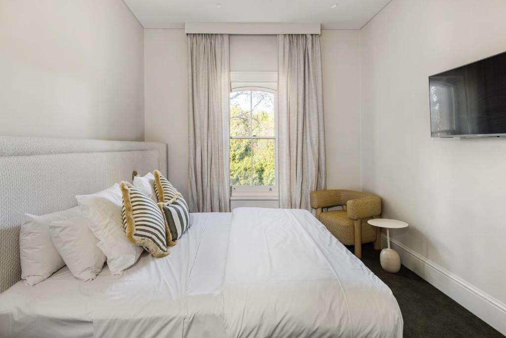 - une chambre avec un lit blanc avec des oreillers et une fenêtre dans l'établissement The Stirling Hotel, à Stirling