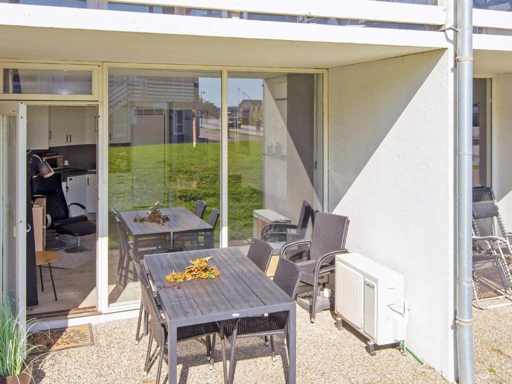 a patio with a table and chairs and a computer on it at 4 star holiday home in Ringkøbing-By Traum in Ringkøbing