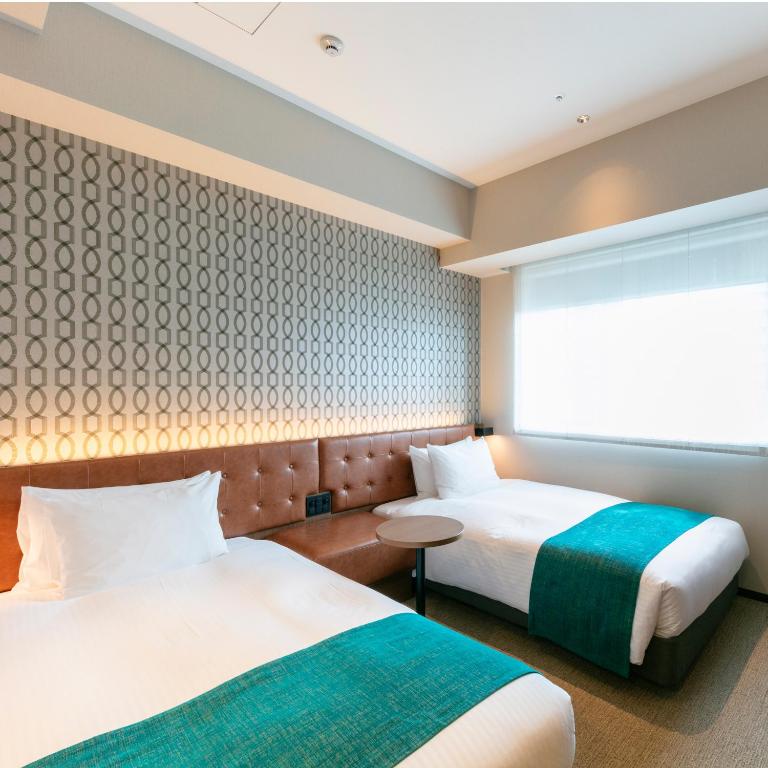 Postel nebo postele na pokoji v ubytování Kobe Hotel Juraku