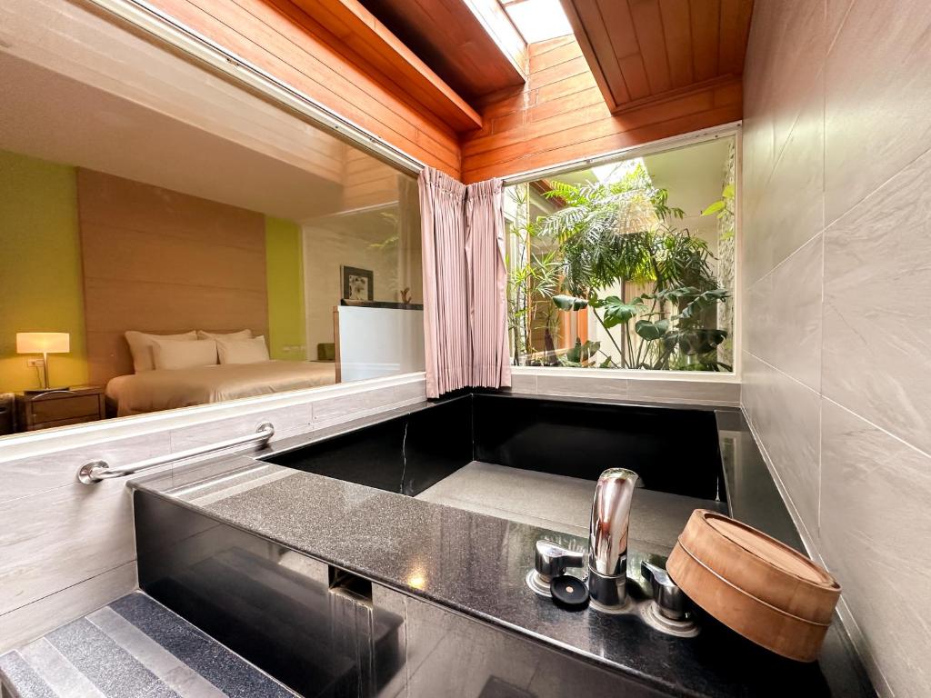 a bathroom with a sink and a window with a bed at Yage Hotspring House in Jiaoxi