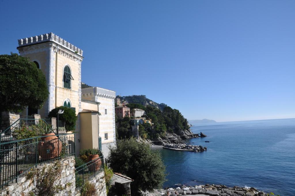 un edificio sul fianco di una scogliera vicino all'oceano di Castello Canevaro a Zoagli