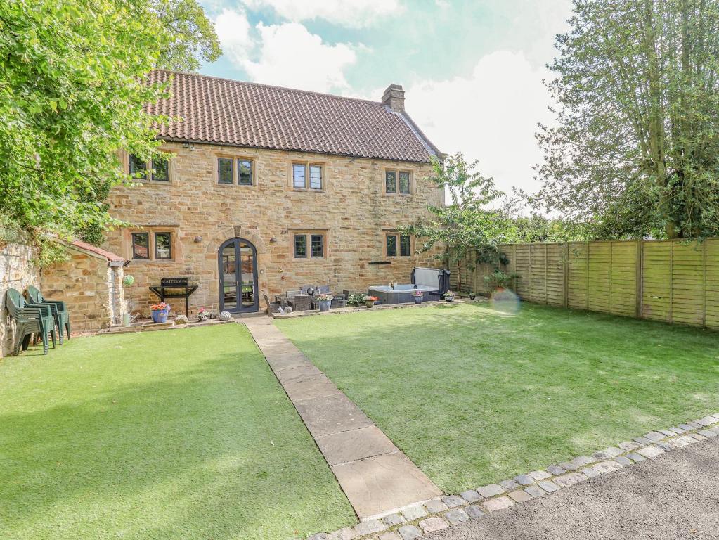 a house with a large yard with a fence at The Gatehouse in Sutton in Ashfield