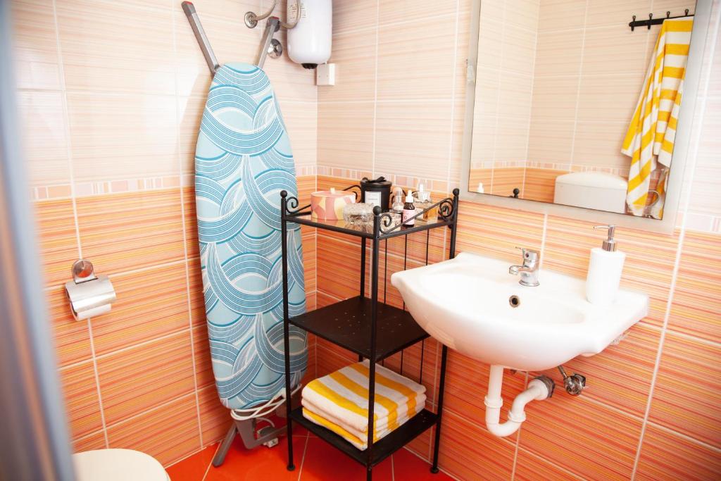 baño con lavabo y tabla de surf en Rosa di Pirano, en Piran