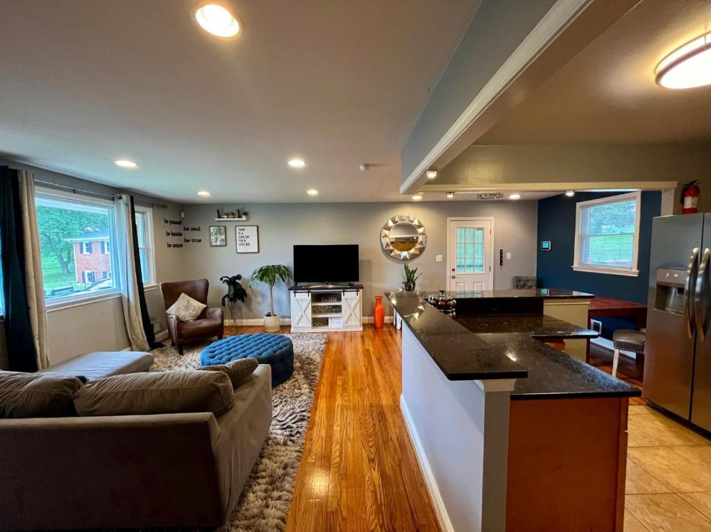 eine Küche und ein Wohnzimmer mit einem Sofa und einem Tisch in der Unterkunft Cozy Cul de Sac Maryland Home near FedEx Field in District Heights