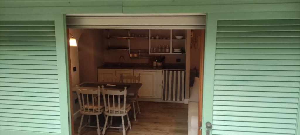 eine Küche und ein Esszimmer mit einem Tisch und Stühlen in der Unterkunft Bilocale a due passi dal mare immerso nel verde in Castiglioncello