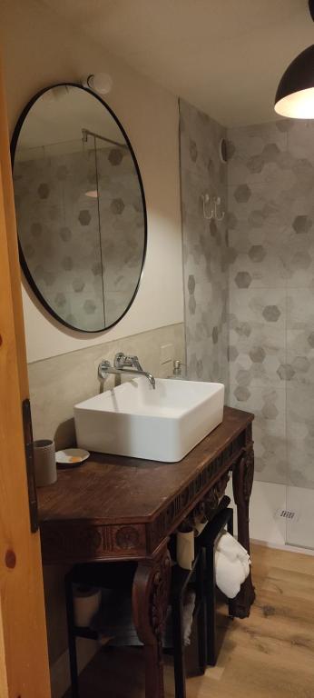 a bathroom with a white sink and a mirror at Bilocale a due passi dal mare immerso nel verde in Castiglioncello