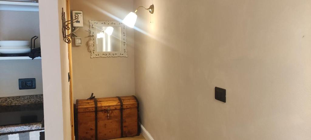 a hallway with a wooden chest next to a mirror at Bilocale a due passi dal mare immerso nel verde in Castiglioncello