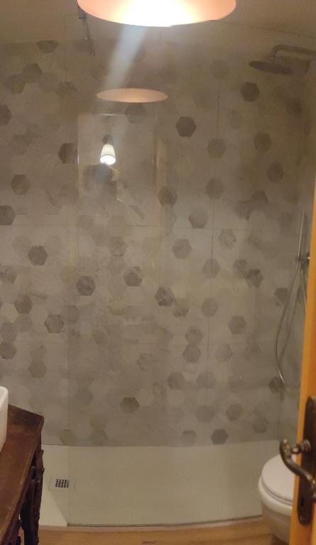 a bathroom with a toilet and a wall covered in paper at Bilocale a due passi dal mare immerso nel verde in Castiglioncello