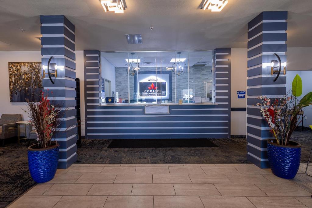 a lobby with blue and white striped walls and potted plants at Coratel Inn & Suites by Jasper Inver Grove Heights in Inver Grove Heights