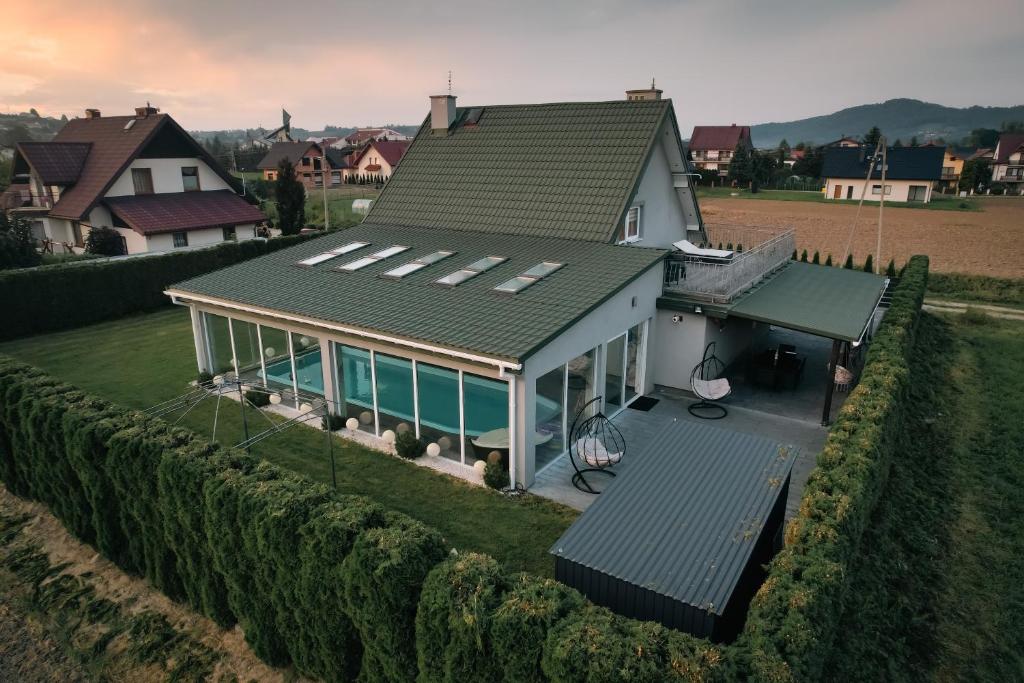 ein Haus mit einem grünen Dach auf einem Feld in der Unterkunft ŁOSOSINA 365 Dom z basenem 