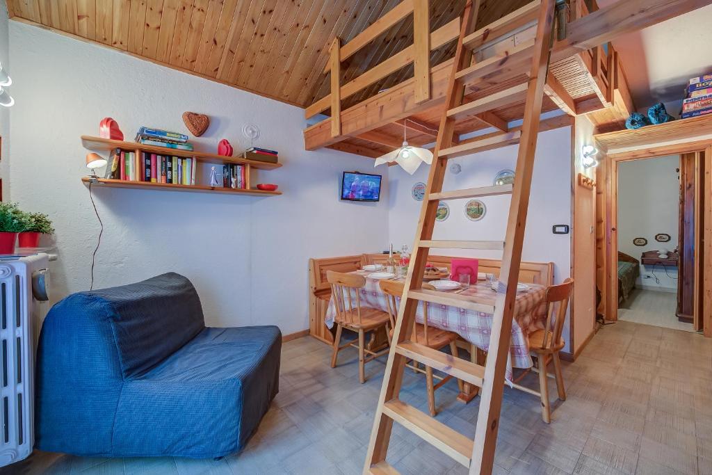 a room with a loft bed and a table and chairs at Appartamento Rochebrune 200m from Ski - Happy Rentals in Claviere
