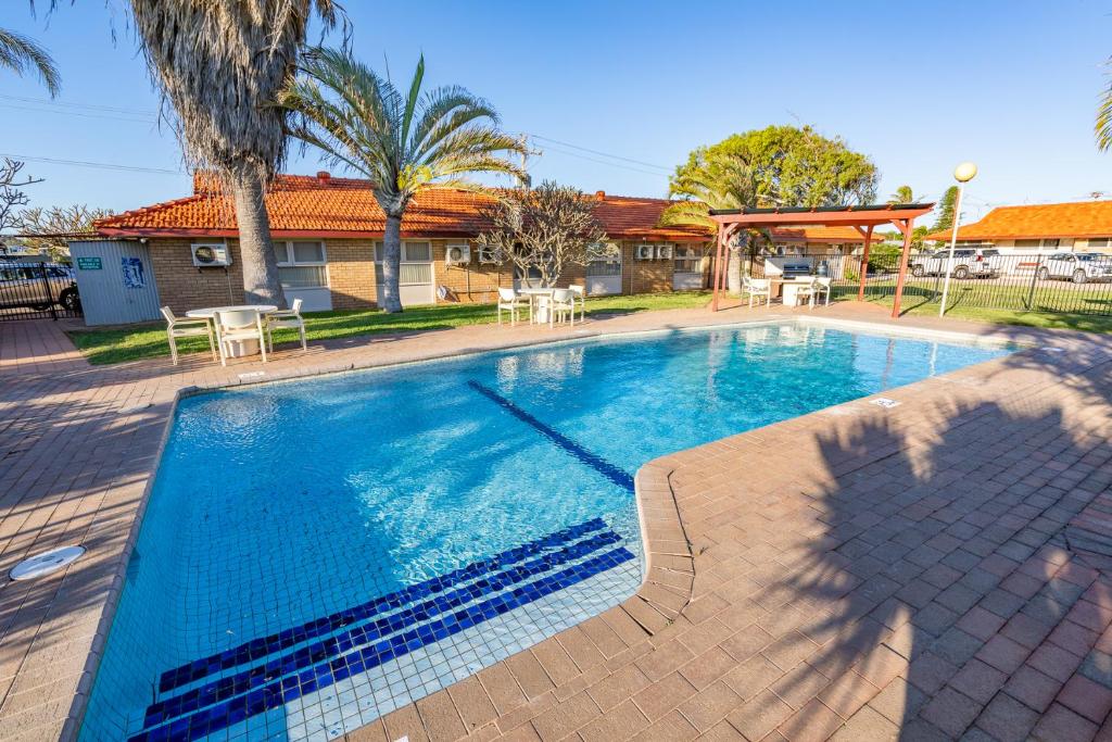 a swimming pool in front of a house at Hospitality Carnarvon, SureStay Collection by Best Western in Carnarvon