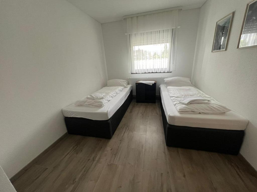 Duas camas num pequeno quarto com uma janela em Timeless: Schönes 4 Zimmer Apartment EG em Trossingen