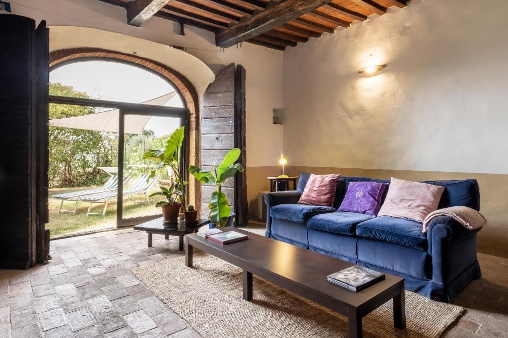 een woonkamer met een blauwe bank en een tafel bij Casale Pian Di Menta in Manciano