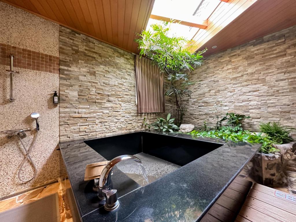 a kitchen with a sink and a brick wall at Yage Hotspring House in Jiaoxi