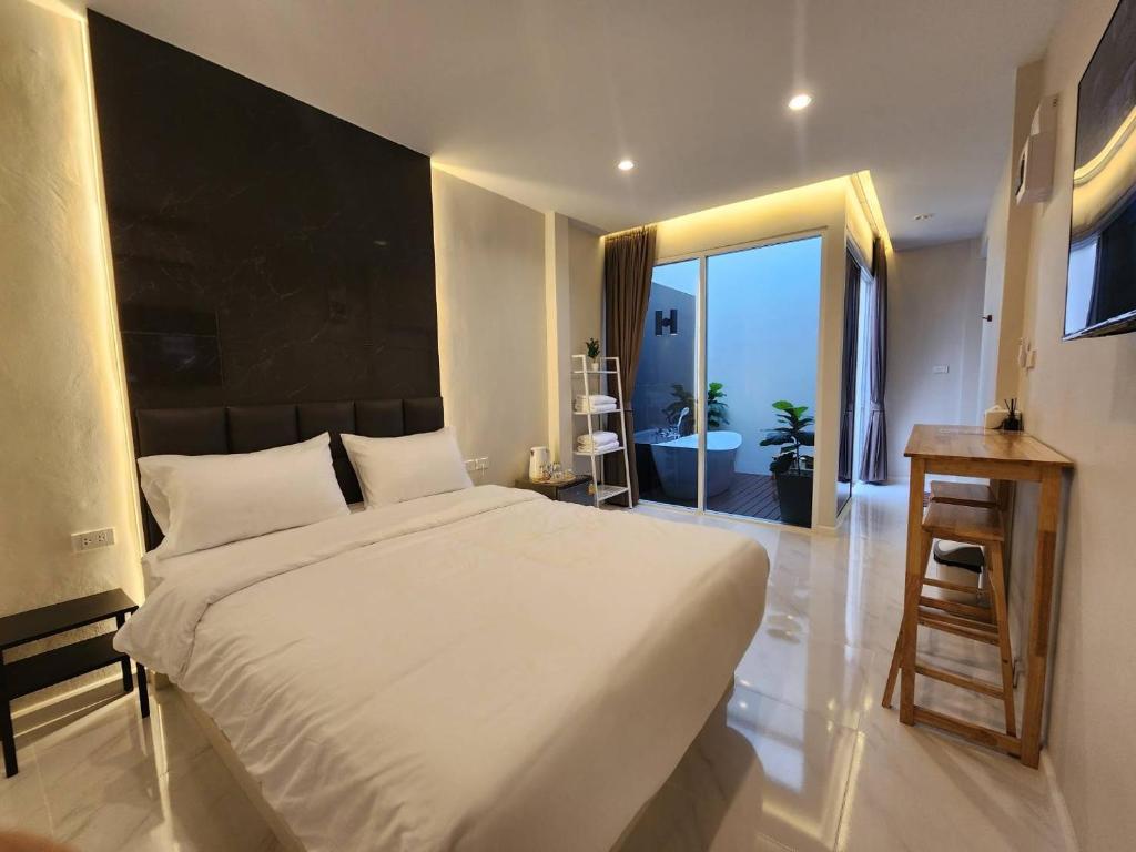 1 dormitorio con 1 cama blanca grande y ventana grande en KVILLA, en Ban Khlong Bang Chak