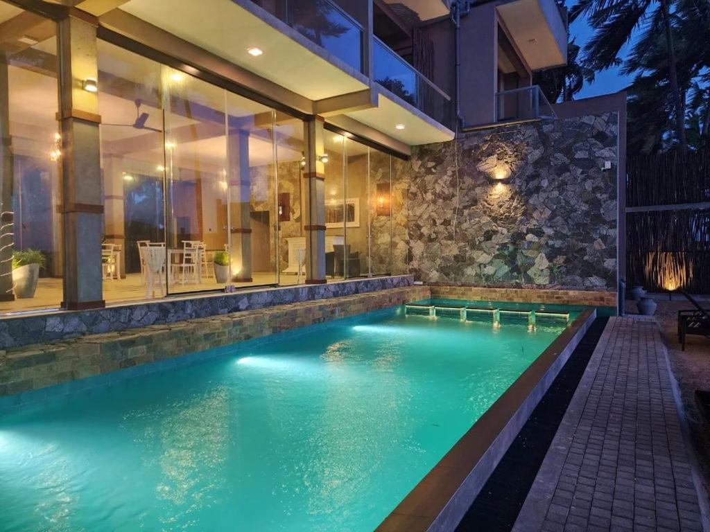 una piscina en medio de una casa en Adique's Resorts en Marawila