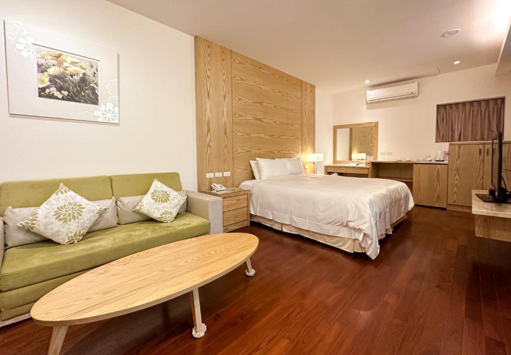 a hotel room with a bed and a couch at Yage Hotspring House in Jiaoxi