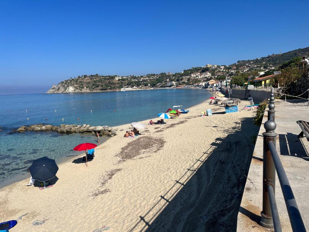 a beach with umbrellas and people on the sand at Miriasol Bed and Breakfast in Capo Vaticano