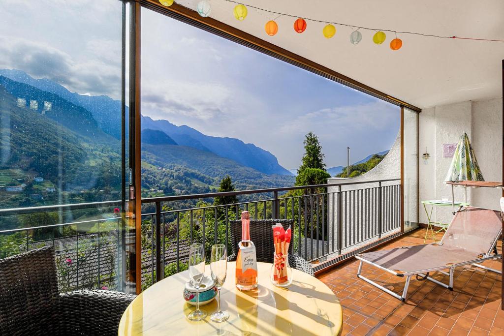a balcony with a table and a view of mountains at Villa Delle Rose - Happy Rentals in Arogno