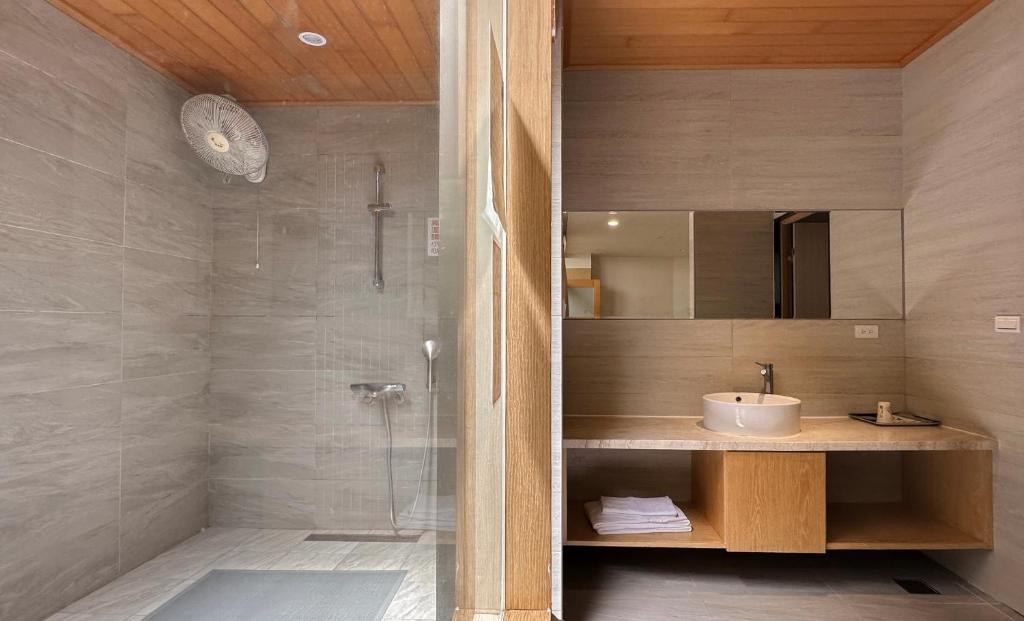 a bathroom with a sink and a shower at Yage Hotspring House in Jiaoxi