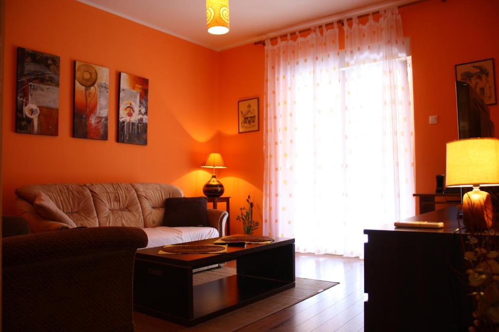 sala de estar con paredes de color naranja y sofá en Apartment Sendy, en Zadar