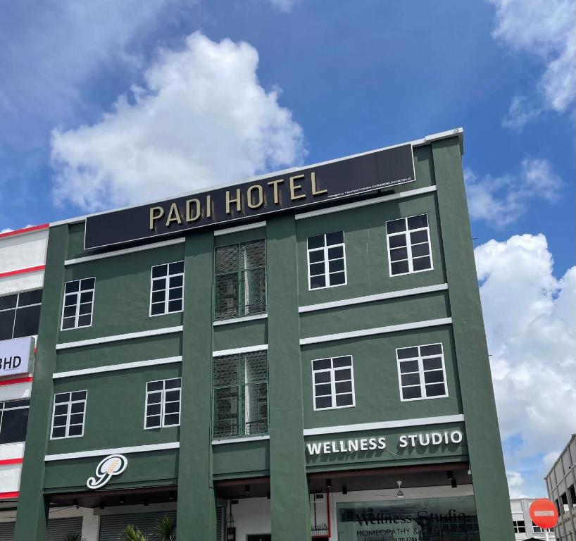a green building with a sign for a hotel at Padi Hotel Alor Setar in Alor Setar