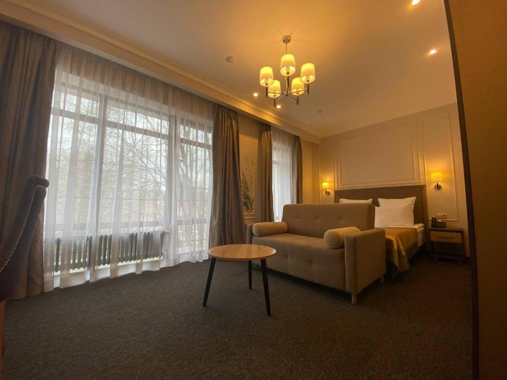 a living room with a couch and a bed and a table at Aura Hotel & Spa in Vologda