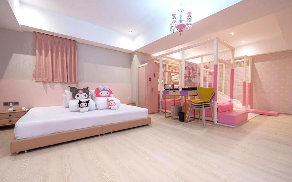 Jangyu Almond Kids Hotel في Gimhae: غرفة نوم مع سرير مع اثنين من الحيوانات المحشوة عليه
