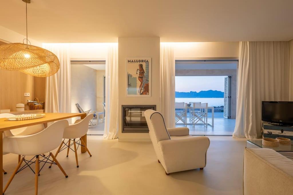 a living room with a table and chairs and a dining room at MOREMAR - Una Casa Especial Junto al Mar in Alcudia