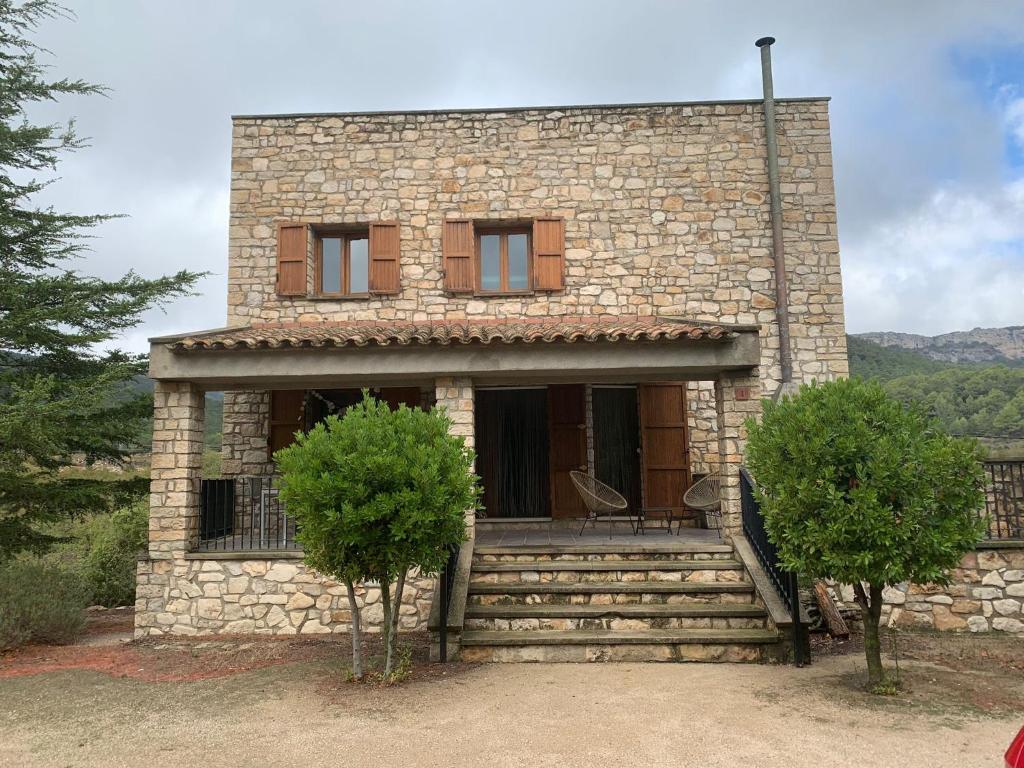 a stone house with two trees in front of it at Casa Major in Mont-ral