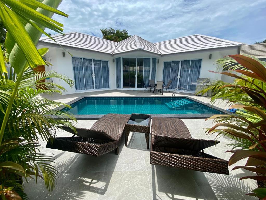 una piscina con dos sillas y una casa en 2 Bedroom Paradise Island Villa, en Lipa Noi