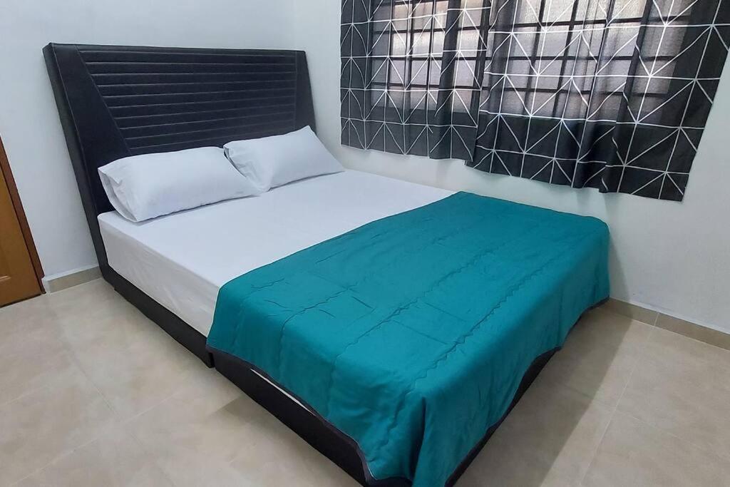 a bedroom with a bed with a blue blanket at SDA Homestay Pool @StadiumDarulAman Untuk Muslim Sahaja in Alor Setar