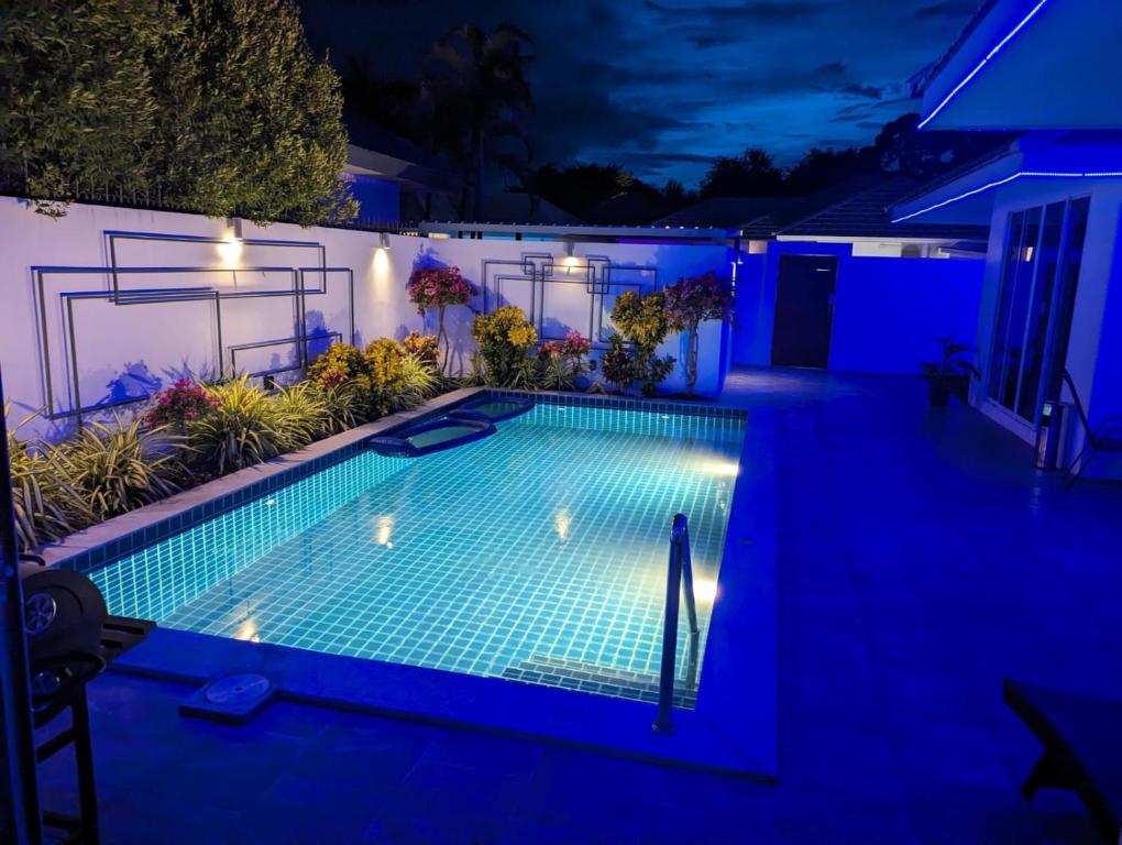 uma piscina à noite com luzes azuis em The Oasis Villa Just 150m to the Beach em Koh Samui