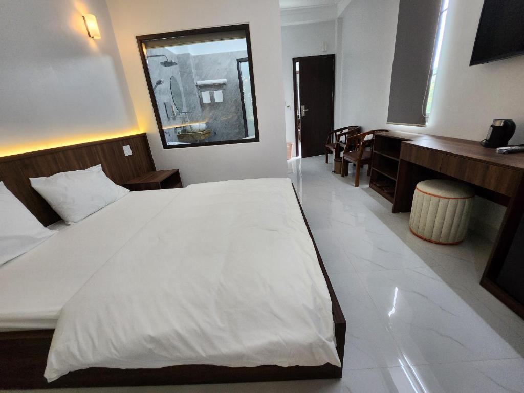 KL Retreat Hotel في Thanh Hóa: غرفة نوم مع سرير أبيض كبير في غرفة