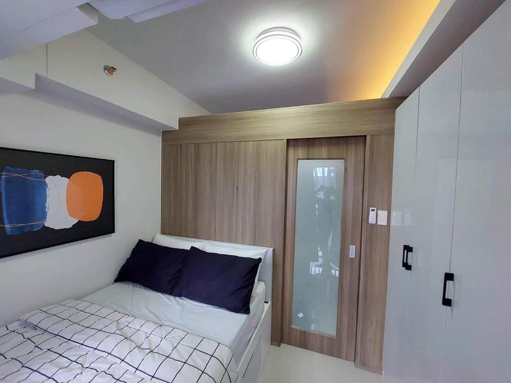 Habitación pequeña con cama y puerta de cristal en 1 Bedroom in Pasay Mall of Asia- HAVEN GRACE, en Manila