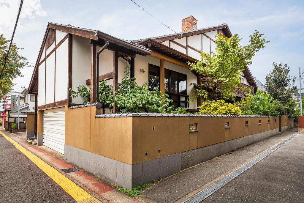 a building with plants on the side of a street at Baikoen in Fukuoka