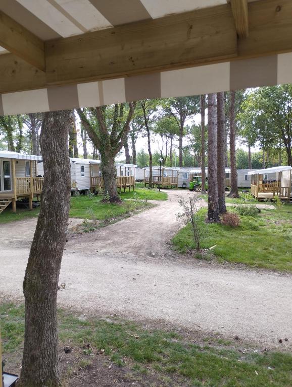 un camino de tierra con árboles y casas móviles en MOBIL HOME, en Piriac-sur-Mer