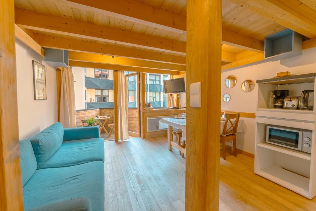 un salon avec un canapé bleu et une table dans l'établissement Résidence Grand Roc - Campanules 322 - Happy Rentals, à Chamonix-Mont-Blanc