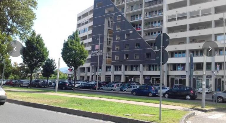 a parking lot with cars parked in front of a building at Qatar Apartment in Cosenza
