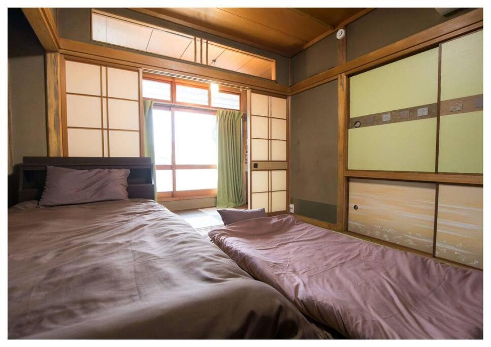 a bedroom with a large bed and a window at I Love Matsuyama in Matsuyama