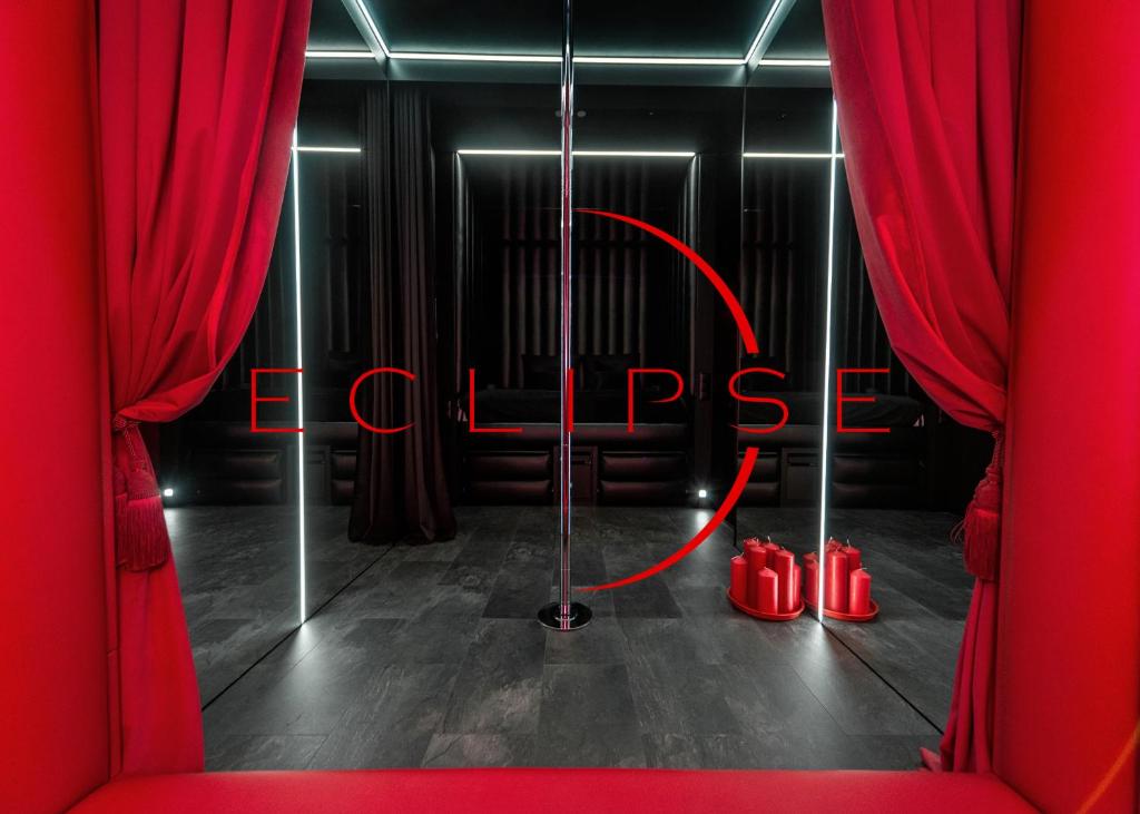 una habitación con cortinas rojas y zapatos rojos en Eclipse Red Room, en Bielsko-Biala