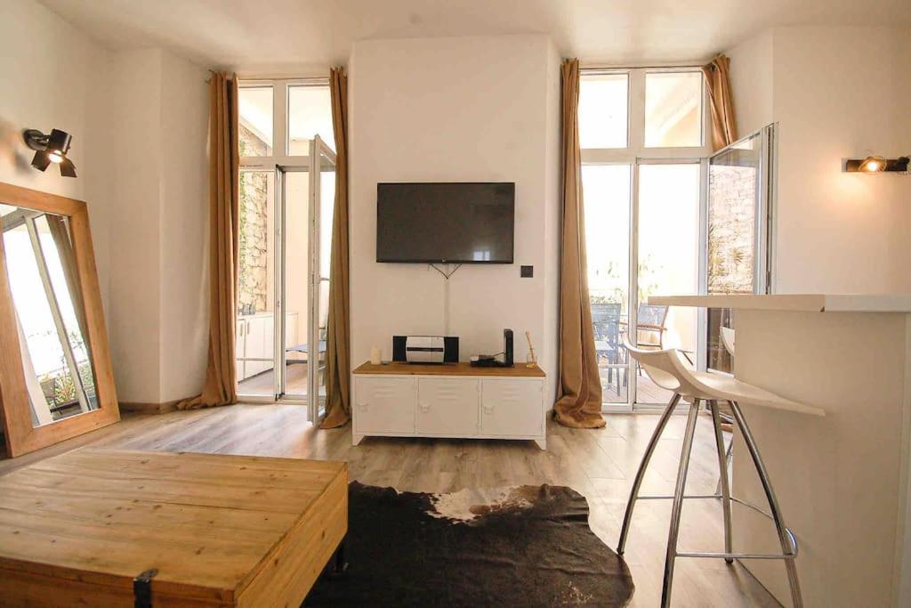 un salon avec une télévision à écran plat au mur dans l'établissement keep in touch 2 CHAMBRES AVEC TERRASSE ET GARAGE, à Cannes
